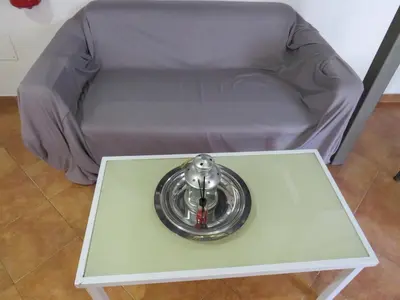 a silver sink on a table in front of a couch at Loft with terrace in the city centre in Palermo