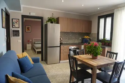 a kitchen with a blue couch and a wooden table at Maria's Home in Altavilla Milicia