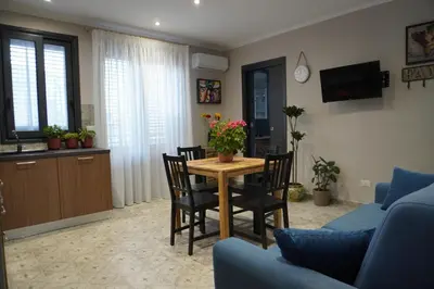 a living room with a table and chairs at Maria's Home in Altavilla Milicia