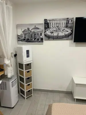a room with two pictures on the wall and a microwave at All'Oro Suite & go in Palermo