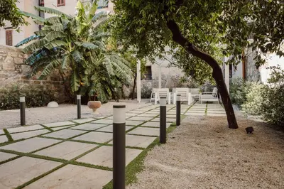 a park with white chairs and a tree at HrD Luxury Rooms in Palermo