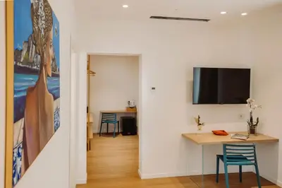 a room with a table and a tv on a wall at HrD Luxury Rooms in Palermo
