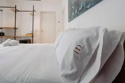 a white bed with a white blanket on it at HrD Luxury Rooms in Palermo
