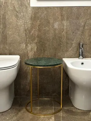 a bathroom with a sink and a table next to a toilet at Rosalia Holiday Home in Palermo