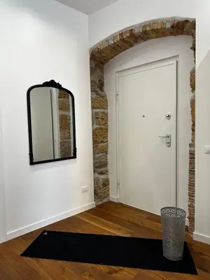 a mirror on a wall next to a door at Rosalia Holiday Home in Palermo