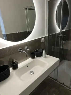 a bathroom with a white sink and a mirror at Rosalia Holiday Home in Palermo