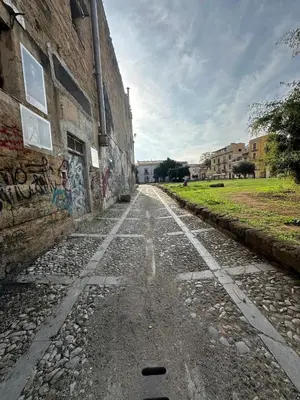 an empty street with graffiti on the side of a building at Rosalia Holiday Home in Palermo