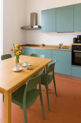 a kitchen with a wooden table with chairs and a vase of flowers at GoriziaHome in Palermo