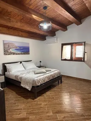 a bedroom with a large bed with a wooden ceiling at A Casa di Frank in Palermo