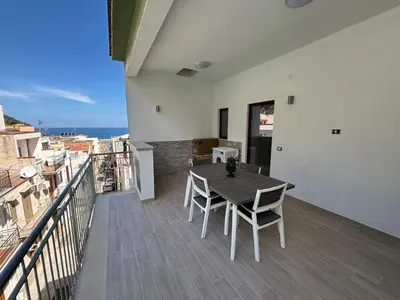 a table and chairs on a balcony with the ocean at Sguardo a Ponente in Castellammare del Golfo