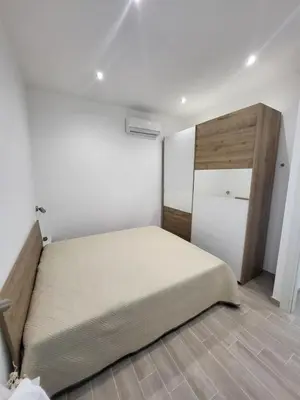 a bedroom with a bed and a white wall at Sguardo a Ponente in Castellammare del Golfo