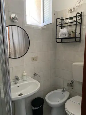 a bathroom with a sink and a toilet and a mirror at Appartamento Nonna Rosalba in Palermo