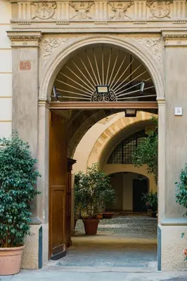 an entrance to a building with an arch with plants at Santa Sofia con Terrazza by Wonderful Italy in Palermo