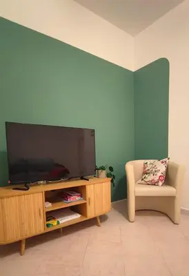 a living room with a flat screen tv and a chair at Casa GADA in Palermo