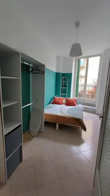 a bedroom with a bed with green walls and a window at Casa GADA in Palermo