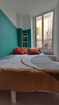 a large bed in a room with a large window at Casa GADA in Palermo