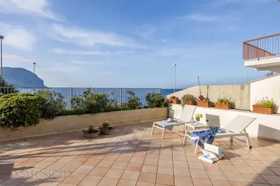 a patio with chairs and a table on a roof at Onda Blu Addaura by DomuSicily in Palermo