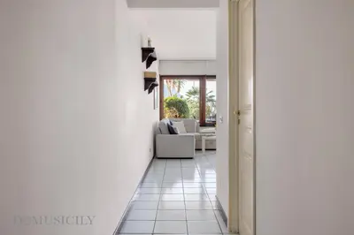 a hallway with a living room with a couch at Onda Blu Addaura by DomuSicily in Palermo