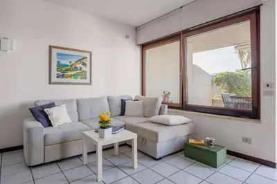 a living room with a couch and a table at Onda Blu Addaura by DomuSicily in Palermo