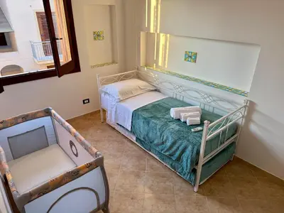 a small bedroom with a bed and a mirror at Carol's Sicily Dream in San Vito lo Capo