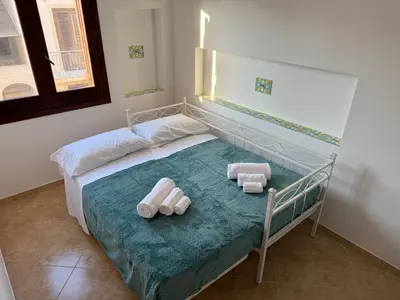 a bedroom with a bed with two towels on it at Carol's Sicily Dream in San Vito lo Capo