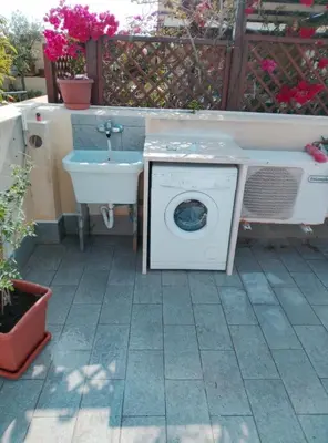 a washing machine and a sink in a yard at Carol's Sicily Dream in San Vito lo Capo