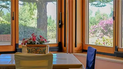 a table with two chairs and a vase with flowers on it at Villa Viola e Giulio in Scopello