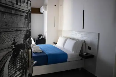 a bedroom with a bed with blue sheets and white pillows at Dimora Garibaldi in Palermo