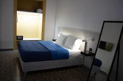 a bedroom with a bed with a blue blanket and a mirror at Dimora Garibaldi in Palermo