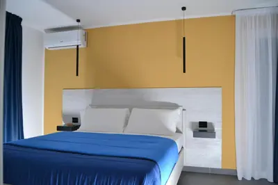a bedroom with a blue bed and yellow walls at Dimora Garibaldi in Palermo