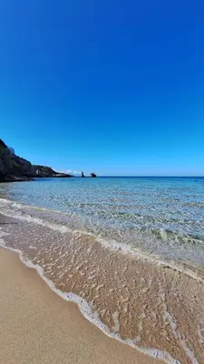 a sandy beach with water and a blue sky at Casa Kialy in Terrasini