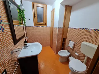 a bathroom with a white sink and a toilet at Casa Kialy in Terrasini