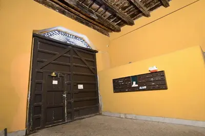 a brown door in a room with a yellow wall at iFlat Casa Riccino in Palermo