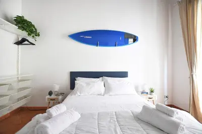 a bedroom with a bed with a surfboard on the wall at iFlat Casa Riccino in Palermo