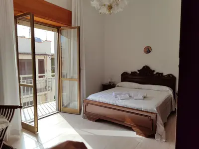 a bedroom with a bed and a sliding glass door at Albachiara in Balestrate