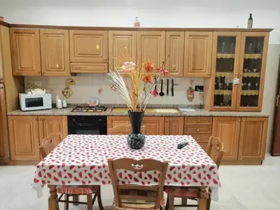 a kitchen with a table with a vase of flowers on it at Albachiara in Balestrate