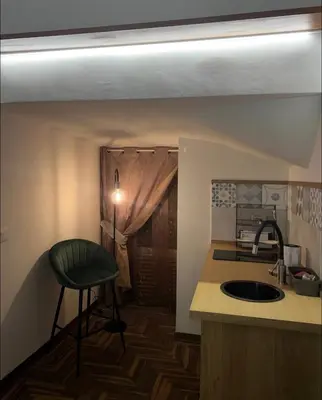 a kitchen with a sink and a green stool in it at Ausa 20 - Tra Storia e Mare in Palermo