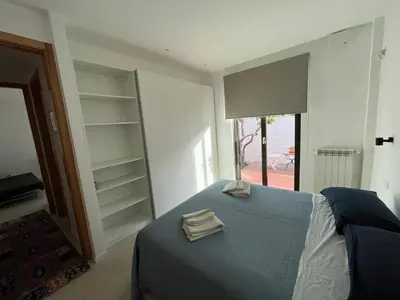 a bedroom with a bed with a blue blanket and shelves at Giunone Garden in Palermo