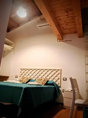 a bedroom with a bed with green sheets and pillows at Guest House Lo specchio sul mare in Santa Flavia