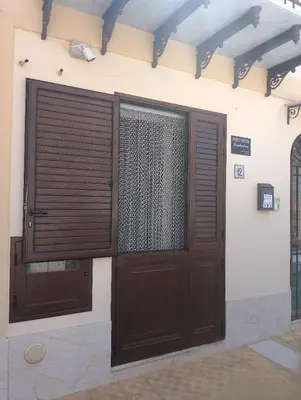 a pair of wooden doors on the side of a building at Guest House Lo specchio sul mare in Santa Flavia