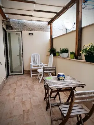 a patio with a wooden table and chairs at Guest House Lo specchio sul mare in Santa Flavia