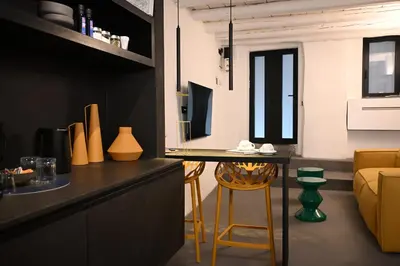 a kitchen and living room with a table and chairs at Suitt Drims 6 in Palermo