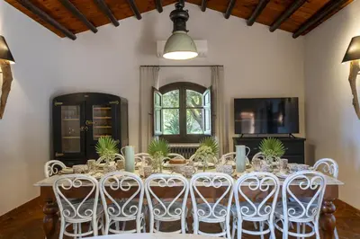 a dining room with a long table with white chairs at Villa Passulunara 14 by Massimo Villas in Lascari