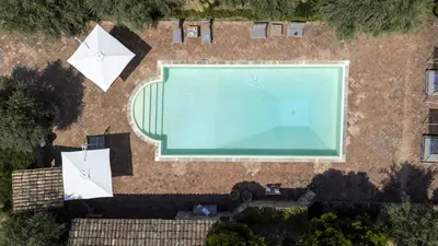 an overhead view of a swimming pool with two umbrellas at Villa Passulunara 14 by Massimo Villas in Lascari