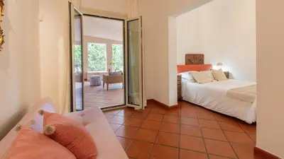 a bedroom with a bed and a sliding glass door at Casale Buccellato 14 by Massimo Villas in Castellammare del Golfo