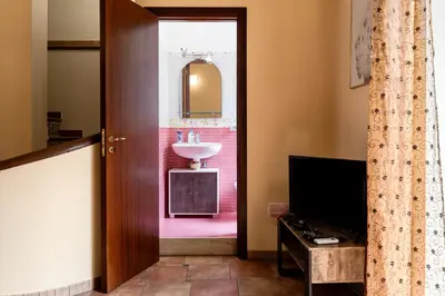 a pink bathroom with a sink and a toilet at casa Fontana in Capaci