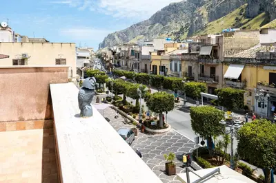 a city with a statue of a dog looking at a street at casa Fontana in Capaci