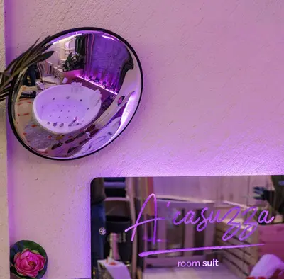 a mirror on a wall next to a purple wall at A' Casuzza Suite Room in Porticello