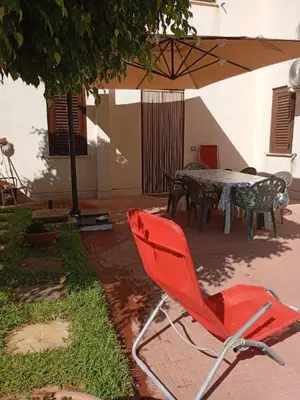 a red chair sitting in a yard with a table at Endless summer in Castelluzzo