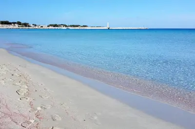 a beach with the ocean and the shoreline at Endless summer in Castelluzzo